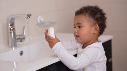 Toddler washing hands with soap